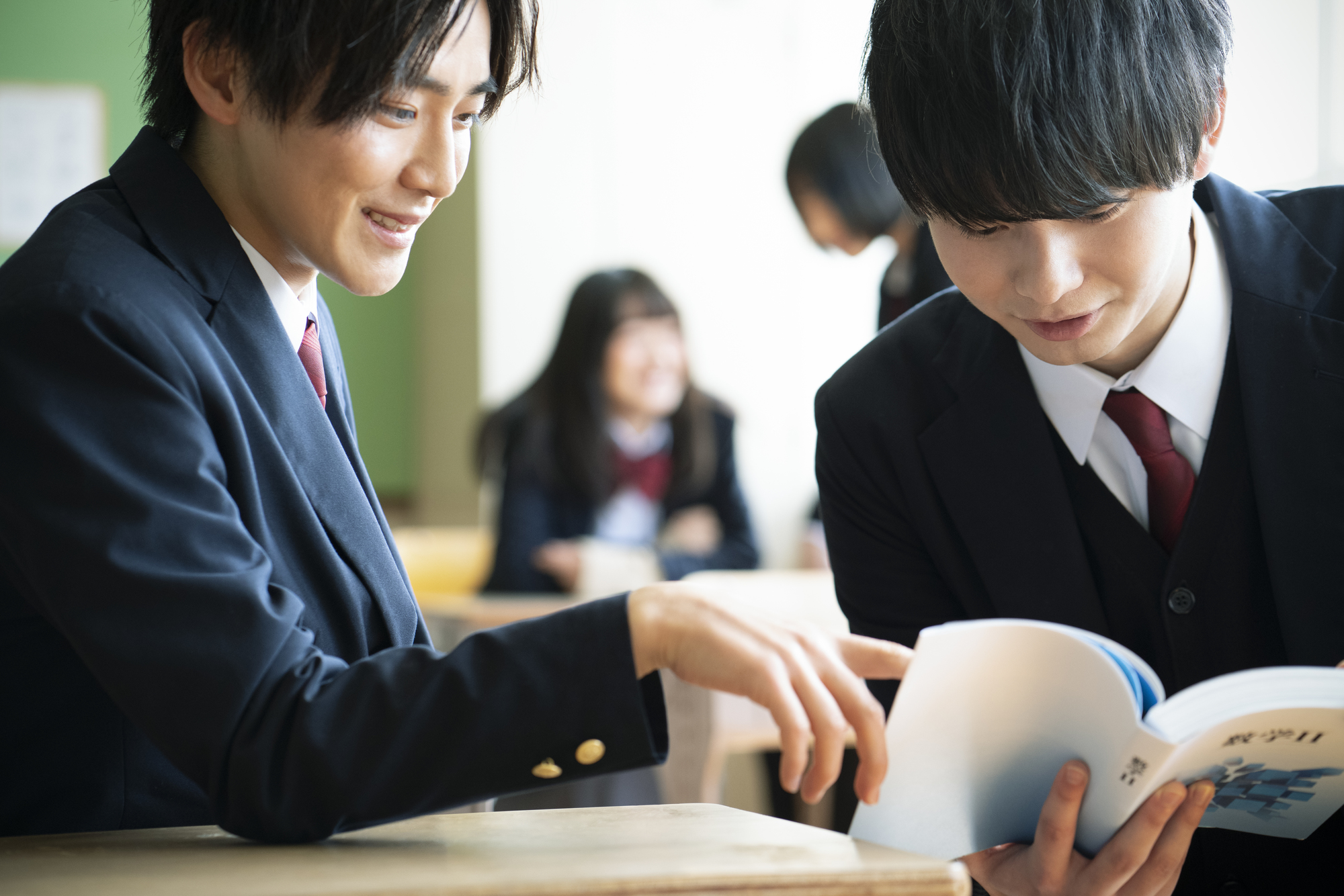 学校の教室で勉強する高校生